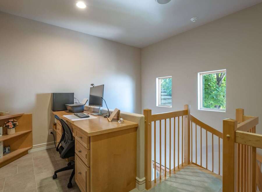 This home office space features a built-in wooden desk with dual monitors and a printer, perfect for productivity.