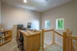 This home office space features a built-in wooden desk with dual monitors and a printer, perfect for productivity.