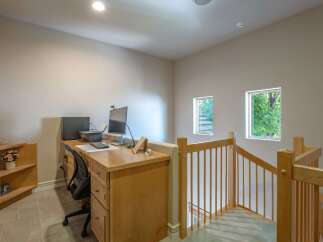 This home office space features a built-in wooden desk with dual monitors and a printer, perfect for productivity.