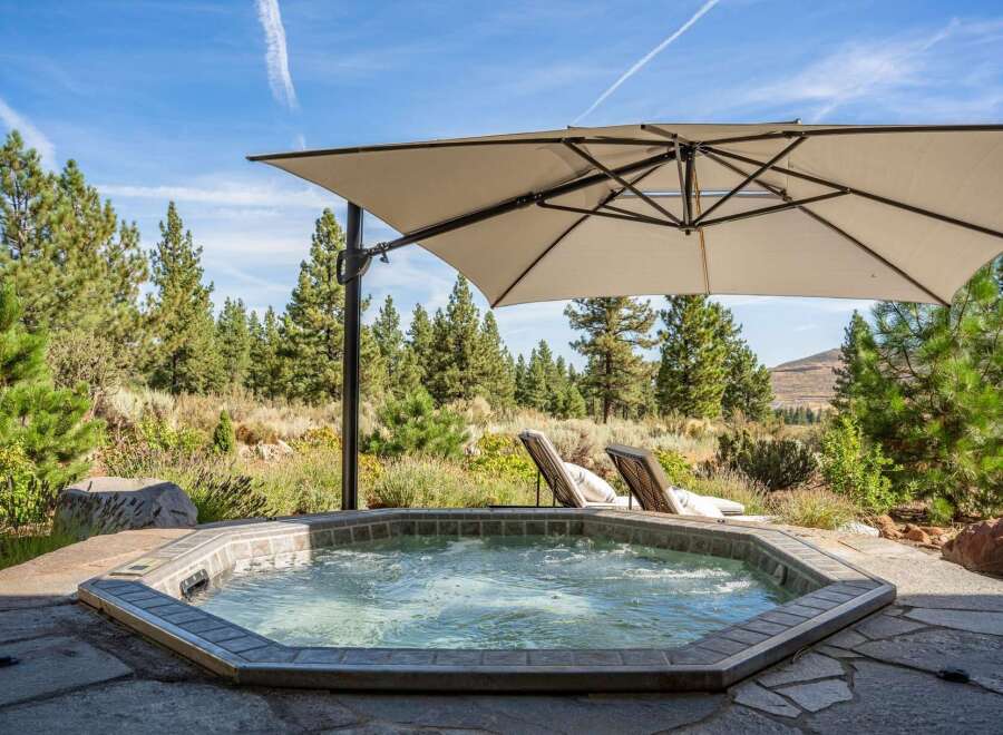Indulge in ultimate relaxation with this luxurious outdoor hot tub, perfectly situated amidst a serene natural landscape.