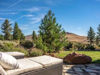Enjoy breathtaking mountain views from this stunning outdoor living space, complete with comfortable chaise lounges perfect for soaking up the sun.
