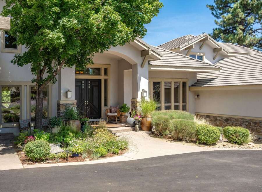Discover this stunning home featuring a grand entrance with double doors and a covered porch, perfect for welcoming guests.