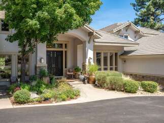 Discover this stunning home featuring a grand entrance with double doors and a covered porch, perfect for welcoming guests.