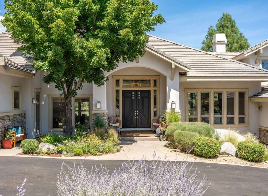 Discover this stunning home featuring a grand entrance with elegant double doors and large windows.