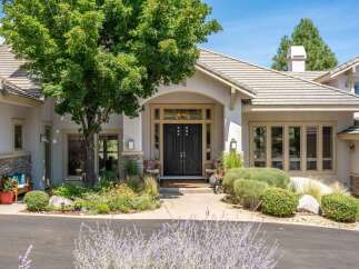 Discover this stunning home featuring a grand entrance with elegant double doors and large windows.