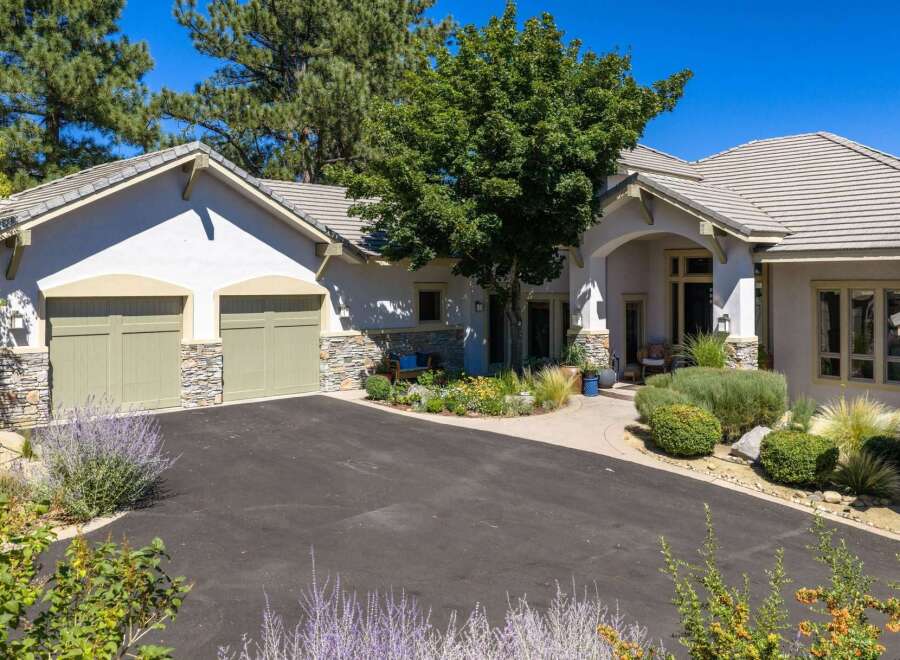 Discover this stunning home featuring a welcoming driveway leading to a charming entrance.