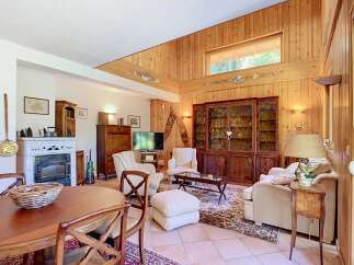 This charming living room features a cozy fireplace and a beautiful wooden cabinet, perfect for displaying your treasures.