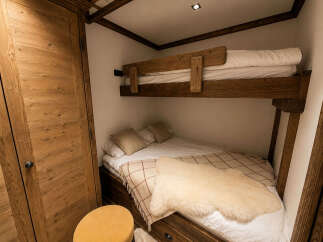 Experience cozy living with this charming bunk bed setup, perfect for maximizing space in a compact room.