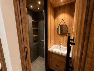 Experience rustic charm in this modern bathroom featuring a sleek shower enclosure with built-in shelving and a stylish vanity with a vessel sink.