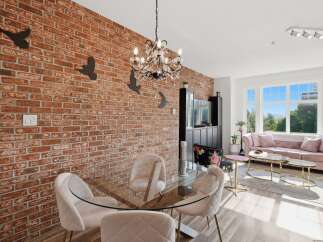 Experience modern living in this stunning dining and living area, featuring a striking exposed brick accent wall that adds industrial charm.