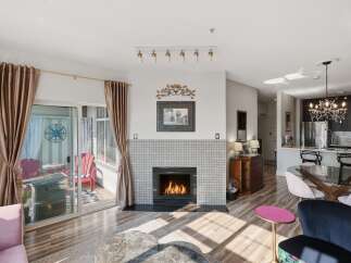 Experience modern living in this stunning open-concept space, featuring a cozy fireplace and elegant tile surround.