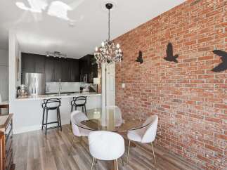 Experience modern urban living in this stylish condo featuring an open-concept kitchen with sleek dark cabinetry and a breakfast bar perfect for casual dining.