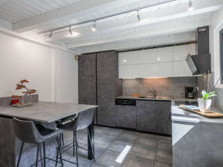 Discover this modern kitchen featuring sleek, gray marble-patterned cabinetry and white high-gloss upper cabinets for a sophisticated look.