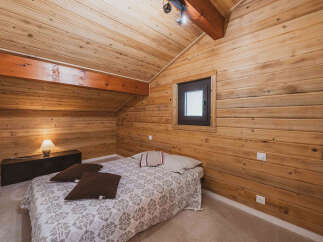 Experience rustic charm in this cozy bedroom, featuring warm, wood-paneled walls and ceiling that create a serene, cabin-like atmosphere.