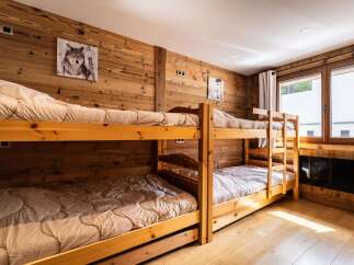 This charming bedroom features a set of sturdy wooden bunk beds, perfect for accommodating guests or family.
