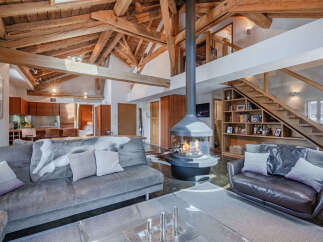 Experience luxurious alpine living in this stunning chalet featuring a dramatic suspended fireplace as the centerpiece of the open-plan living area.