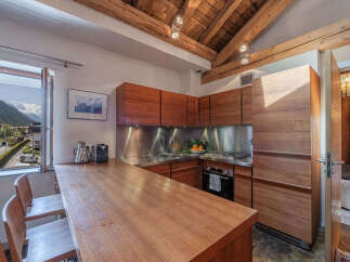 Experience stunning mountain views from this charming kitchen, featuring sleek wooden cabinetry and a spacious breakfast bar.