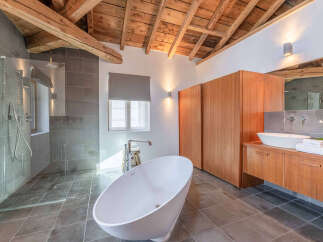 Experience luxury in this stunning bathroom featuring a freestanding bathtub and a spacious walk-in shower with elegant grey tiling.