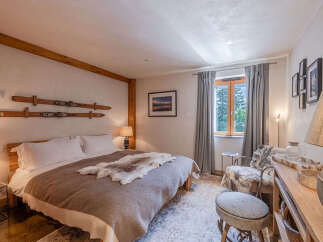 Experience rustic charm in this cozy bedroom, featuring a comfortable queen-size bed adorned with a plush fur throw.
