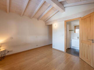 Discover this charming room featuring a vaulted wooden beam ceiling and warm hardwood floors.