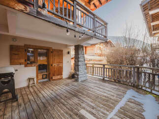 Enjoy outdoor living on this spacious wooden deck, complete with a barbecue grill for summer cookouts.