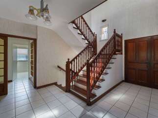 Step into this charming home featuring a grand wooden staircase that serves as the centerpiece of the entryway.