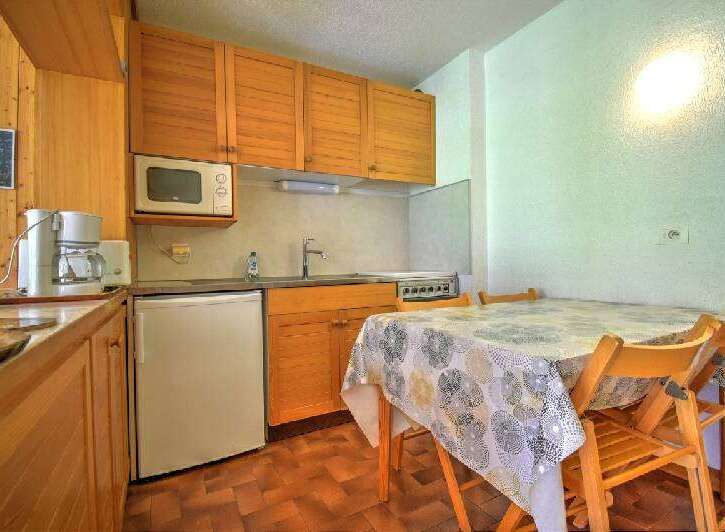 This charming kitchen area features warm wooden cabinetry and a convenient microwave above the countertop.