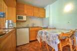 This charming kitchen area features warm wooden cabinetry and a convenient microwave above the countertop.