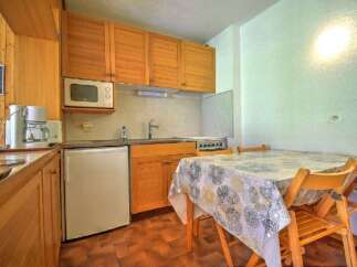 This charming kitchen area features warm wooden cabinetry and a convenient microwave above the countertop.