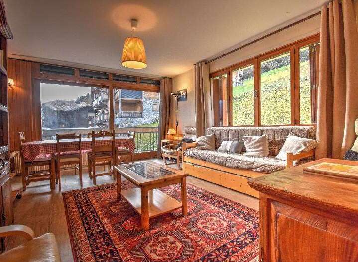 Experience cozy mountain living in this charming apartment, featuring a spacious living and dining area with large windows offering scenic views.