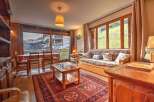 Experience cozy mountain living in this charming apartment, featuring a spacious living and dining area with large windows offering scenic views.