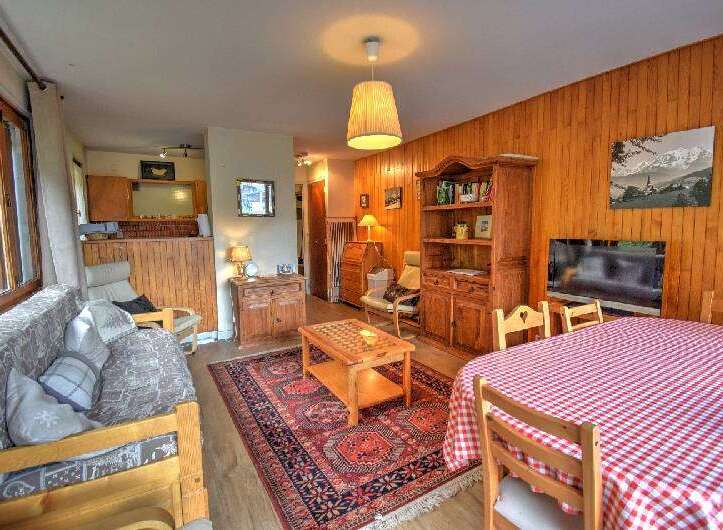 Experience cozy living in this charming mountain retreat, featuring a warm wooden interior and a comfortable living area with a plush sofa.