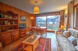 Experience cozy living in this charming apartment, featuring a warm wooden interior and a spacious dining area perfect for family meals.