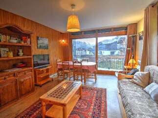 Experience cozy living in this charming apartment, featuring a warm wooden interior and a spacious dining area perfect for family meals.