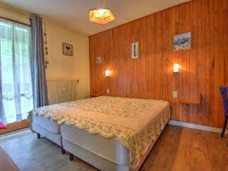 This charming bedroom features two comfortable beds adorned with a decorative throw, perfect for a cozy retreat.