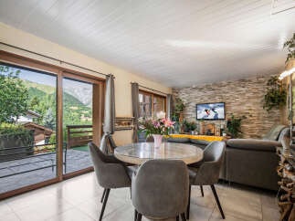 Experience breathtaking mountain views from this stunning living area, featuring a modern dining set perfect for family meals.