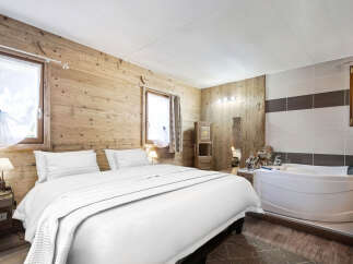 Experience rustic charm and modern luxury in this unique bedroom featuring a cozy wooden interior and a relaxing jacuzzi tub.
