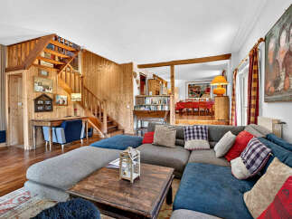 Experience rustic charm in this spacious living area featuring a cozy sectional sofa adorned with colorful throw pillows.