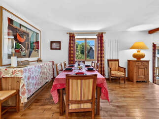 This charming dining room features a large abstract artwork and a rustic wooden table set for a meal.