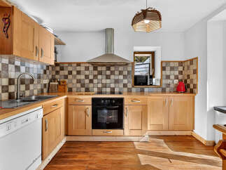 Discover this charming kitchen featuring warm wooden cabinetry and a classic checkered tile backsplash.