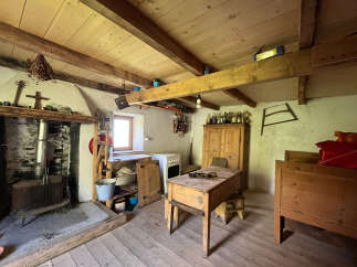 Step into a charming rustic retreat featuring a cozy fireplace with a wood-burning stove, perfect for warm evenings.