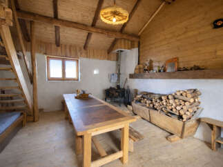 Experience rustic charm in this cozy cabin featuring a spacious wooden dining table perfect for gatherings.