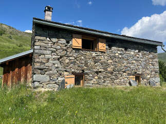 Discover this charming stone house nestled in a serene mountain landscape, perfect for a rustic getaway.