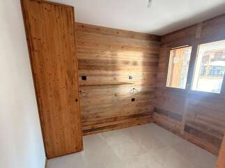 Experience rustic charm in this beautifully appointed room featuring warm, natural wood paneling on the walls and a sleek, modern floor.