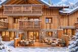 Experience luxurious mountain living in this stunning chalet, featuring a spacious outdoor deck perfect for enjoying the winter wonderland.