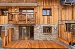 Experience modern alpine living in this stunning property featuring natural wood siding and a stone base.