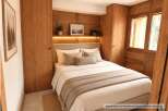 Experience cozy mountain living in this charming bedroom featuring warm wood paneling and integrated cabinetry.