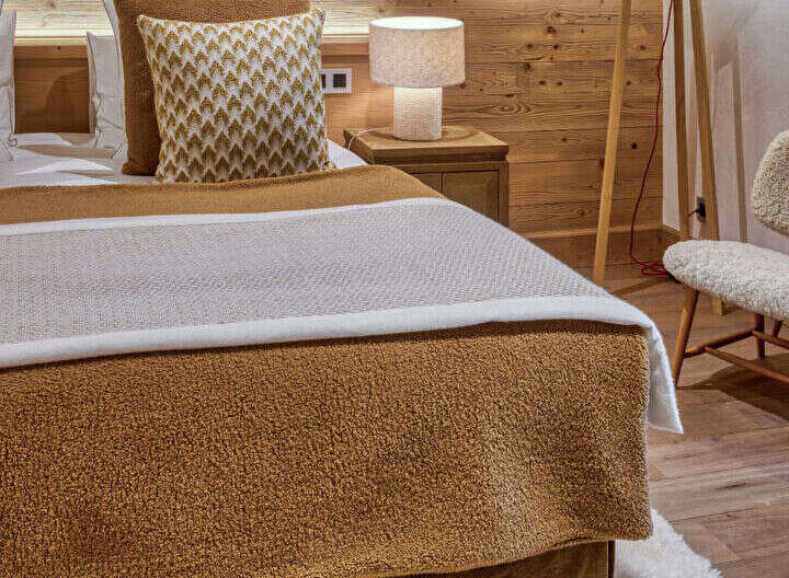 Experience rustic charm and cozy comfort in this beautifully appointed bedroom, featuring warm wood paneling and exposed beams.