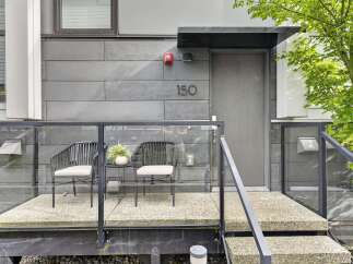 Experience modern living with this stylish entryway featuring a sleek grey door and contemporary siding.
