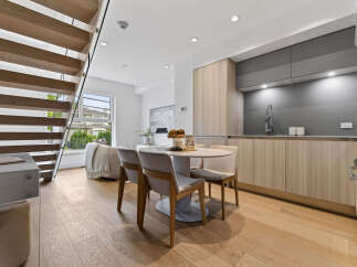 Experience modern living in this stunning open-concept space, featuring a sleek kitchen with contemporary cabinetry and a stylish dining area perfect for intimate gatherings.